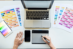 vista-superior-joven-disenador-grafico-que-trabaja-computadora-escritorio-uso-algunas-muestras-color-vista-superior.jpg